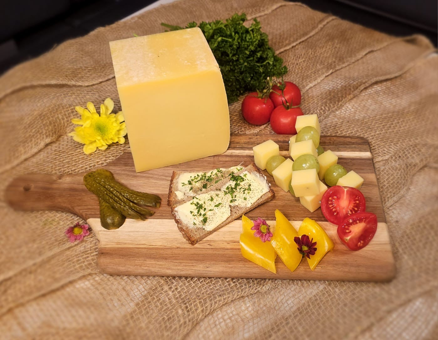 Holzbrett mit Bergkäse, Käse, Traubenmischung milder Bergkäse mit Tomaten, Brot mit Frischkäse